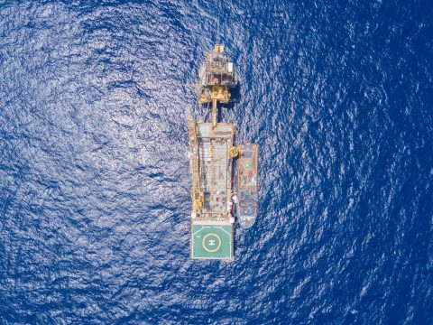 Aerial view of an tender drilling oil rig positioned at sea offshore.